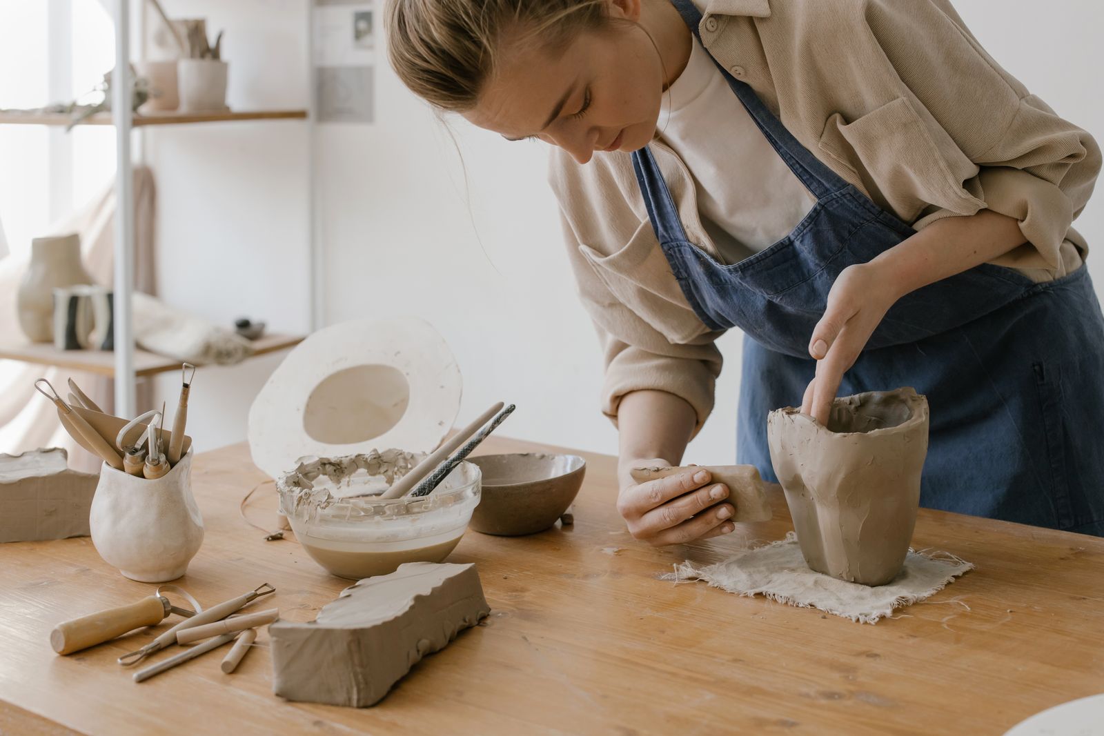 A ceramic artist shaping clay in her studio — the kind of business CHART works with